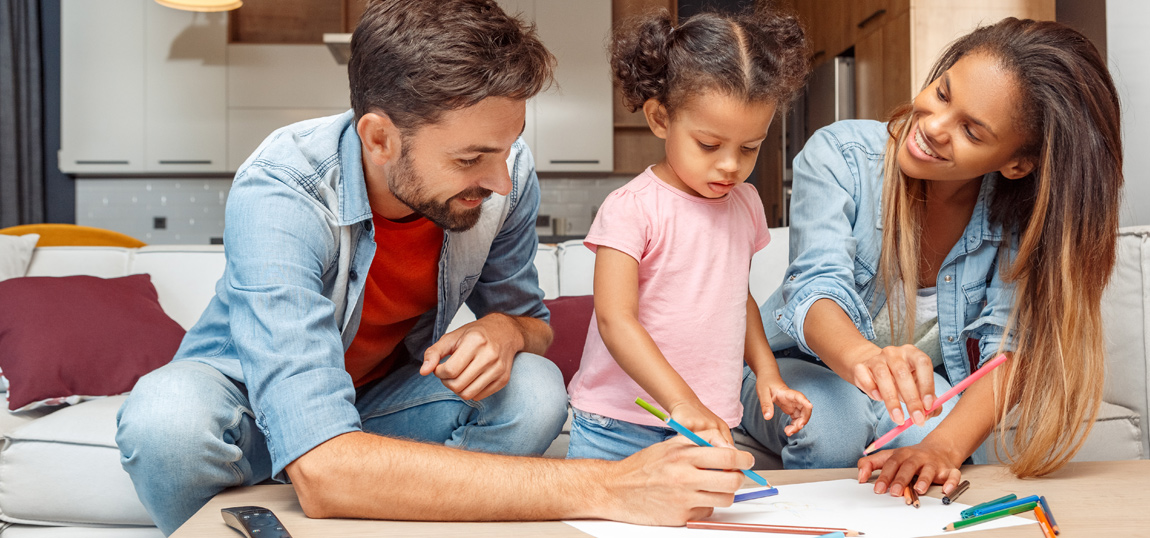 Two young parents playing with their young child.